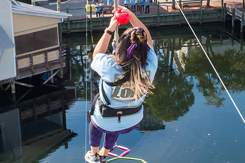A woman ziplining at Baytowne Adventure Zone in Miramar Beach, Florida, which is one of the many things guests can do for free when staying at an Xplorie participating property.