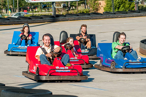 Group of happy people enjoying Go Karts at Broadway Grand Prix in Myrtle Beach, South Carolina, where guests staying at Xplorie participating properties can enjoy a free All You Can Ride Wristband.