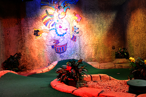 An interior view of the Cancun Lagoon Mini Golf Course in Myrtle Beach, South Carolina, which depicts a Mayan style mural. Guests staying at Xplorie participating properties can enjoy a free round of mini golf.