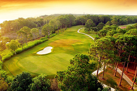 Beautiful green course at Emerald Bay Golf Club in Destin, Florida, where guests staying at Xplorie participating properties can enjoy a free round of golf.