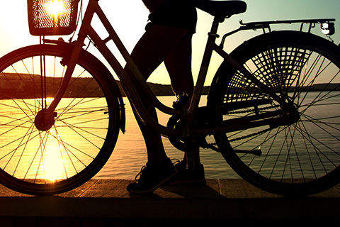 A woman at sunset enjoying her bicycle rental from Island Cruiser Bike Rentals at Hilton Head island, South Carolina, which is available for free at Xplorie participating properties.