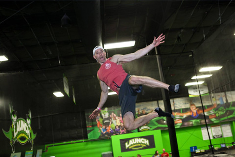 A man in a red shirt bounces on a trampoline at Launch Trampoline Park in Arden, North Carolina, where guests staying at Xplorie participating properties can enjoy a free admission.