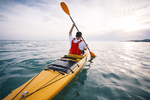 A man kayaking in the waterways of Madeira beach with a full day kayak rental from Mad Beach Surf Shack in St. Pete Beach, Florida. Guests staying at Xplorie participating properties can receive a free admission to the room of their choice.