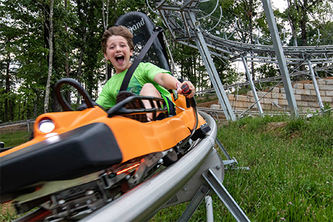 A boy rides the Rocky Top Mountain Coaster in Gatlinburg, Tennessee, where guests staying at Xplorie participating properties can enjoy a free admission.