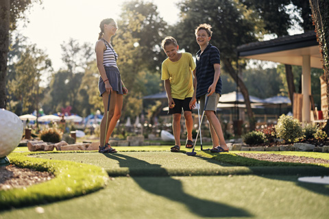 Kids playing at a Jamaican-themed golf course at Runaway Bay Miniature Golf in Garden City, South Carolina, where guests staying at Xplorie participating properties can enjoy a free round of eighteen hole golf.