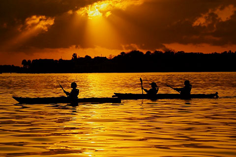 People kayaking during sunset with St. Augustine Eco Tours, which is available for free for guests staying at Xplorie participating properties.